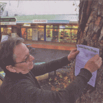 BUSINESS CONCERNS: Second-hand store owner Simon Maddox posting a Save Curtin Shops flyer on a tree in the suburban shopping hub.		Photo: Lucas Coch